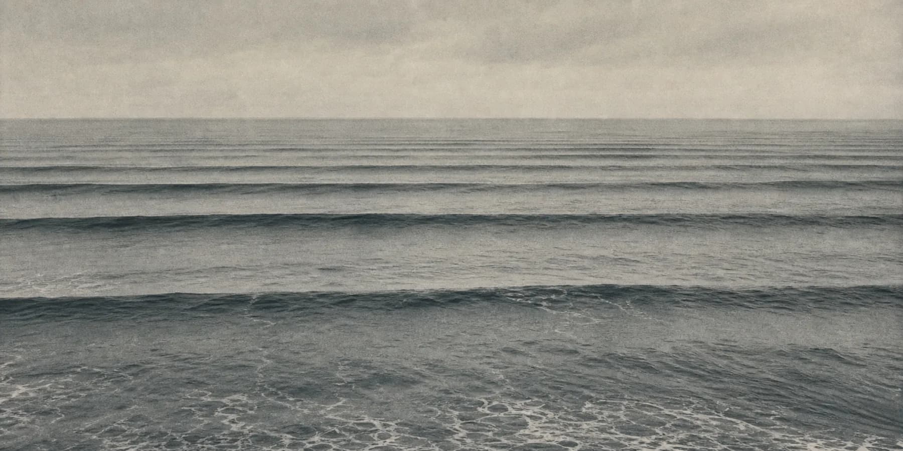 Orderly swell lines marching toward a flat horizon
